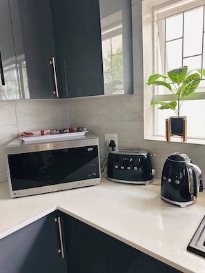 A kitchen with a microwave, toaster, and kettle on the counter. - Entertainers delight near the beach & wine routes! (Cape Town)