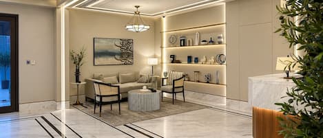 A modern living room with a sofa, chairs, a coffee table, and a bookshelf.