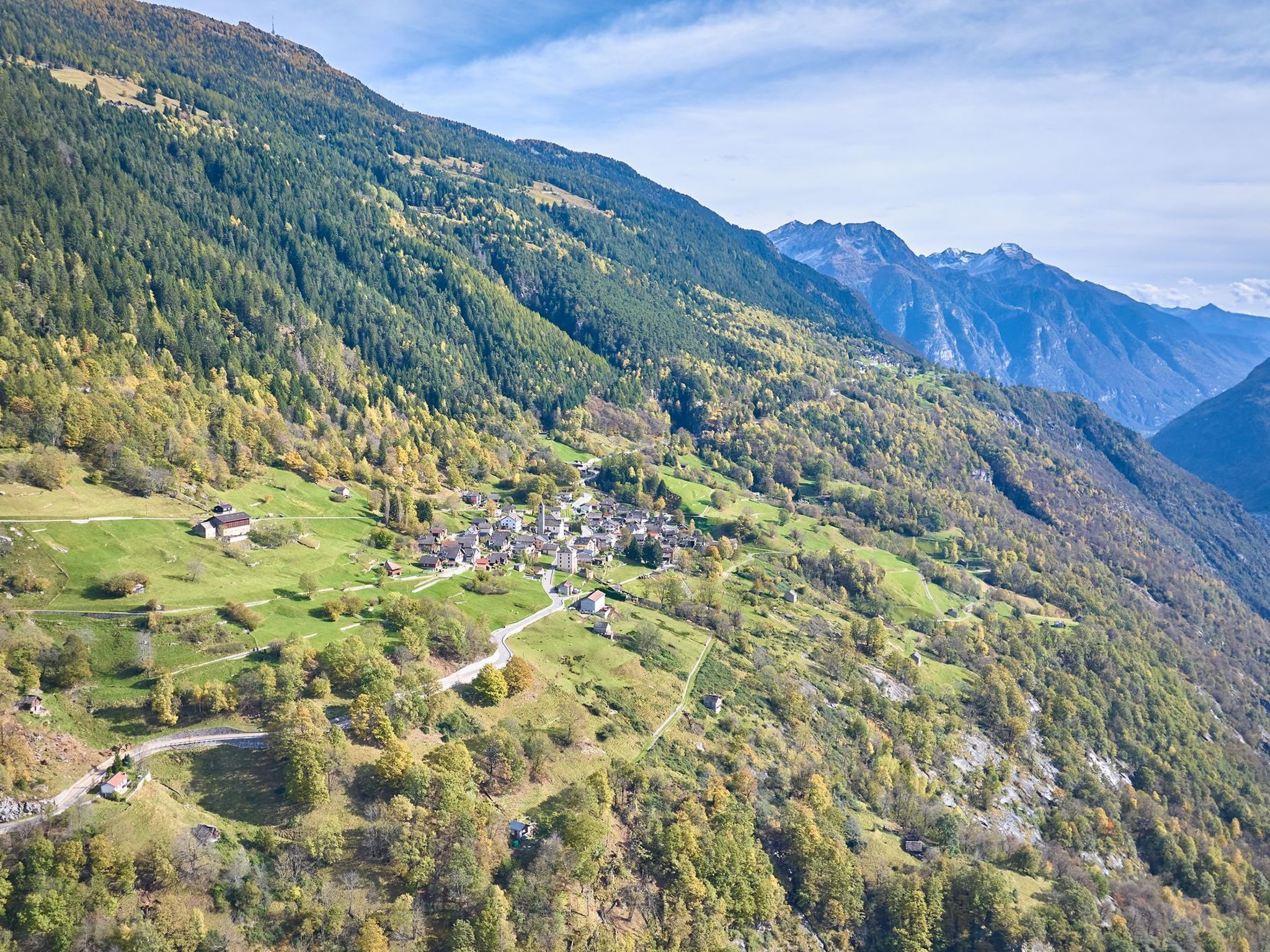 Een bergachtig landschap met een klein dorpje in het dal.