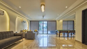 Amplia sala de estar con mesa de billar, un sofá y zona de comedor.