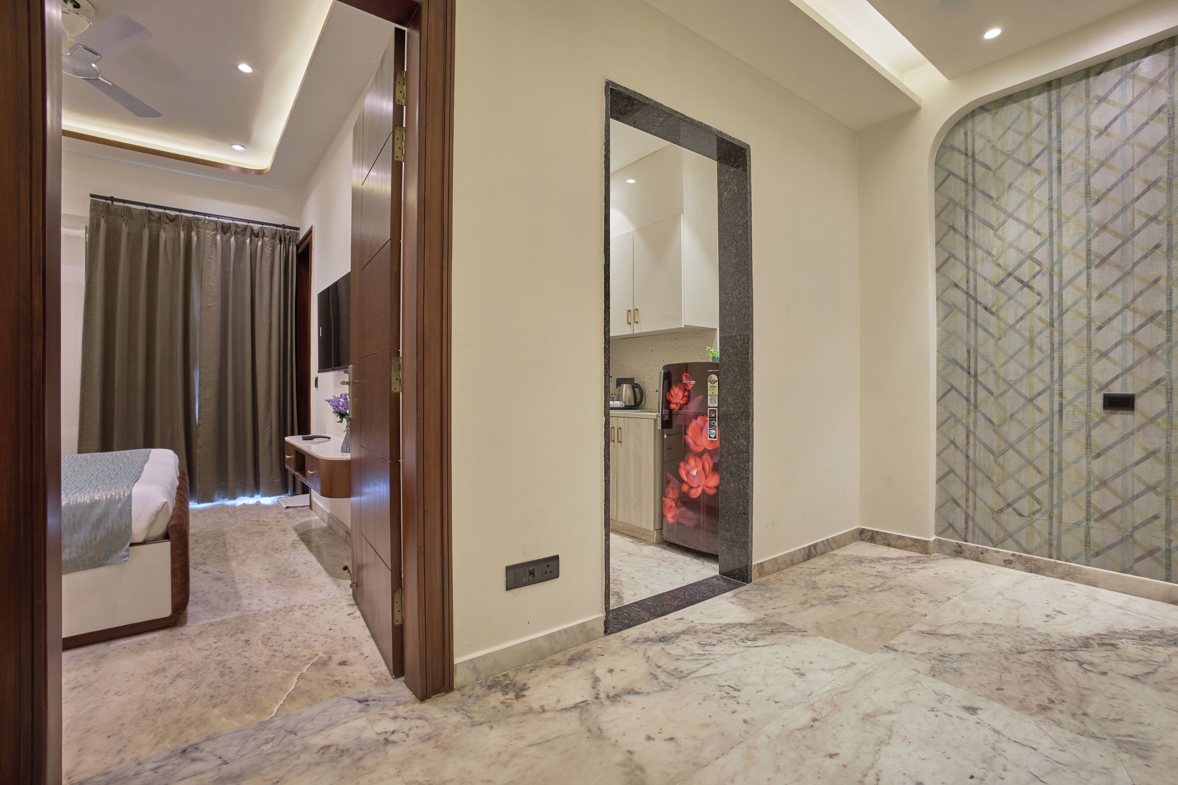 A hotel room with a bed, a vanity, a mirror, and a bathroom with a shower.