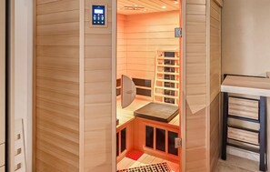 A sauna room with a control panel, a wooden bench, and a bookshelf. - Gorgeous home in Stegersbach with sauna (Stegersbach)