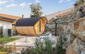 A barrel-shaped building with a stone wall and a wooden deck. - Awesome home in Stegersbach with sauna (Stegersbach)