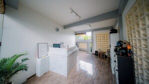 A modern kitchen with a marble countertop, a whiteboard, and a wooden dining area with a table and chairs. - Puspa Guest House (Pererenan)