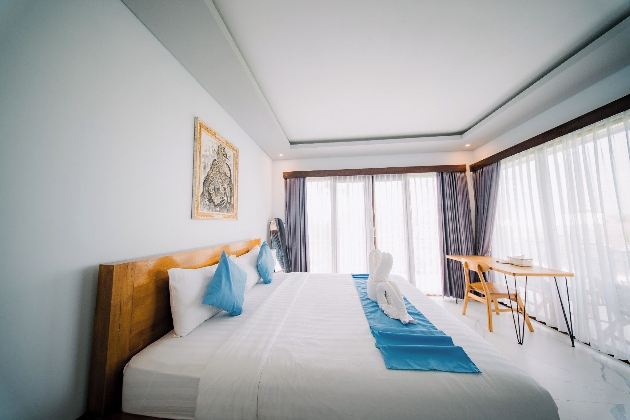 A hotel room with a large bed, a desk, and a view of the city.
