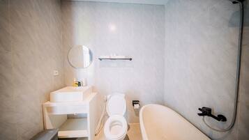 Un baño moderno con inodoro, lavamanos, espejo y ducha.