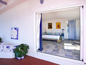 A bedroom with a bed, a nightstand, a lamp, and a window with curtains. - Tolle Villa oberhalb der Bucht Ria de Vigo by Interhome (Pontevedra)