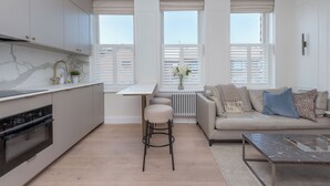 A modern kitchen with a marble countertop, a built-in oven, and a gas stove. - Modern 2BDR with Workspace in Clapham Junction (Greater London)