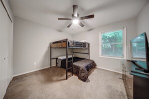 A room with a bunk bed, a ceiling fan, a window with blinds, and a desk with a computer. - 3 Mi to Mill Creek Parks - Pet Friendly! (Youngstown)