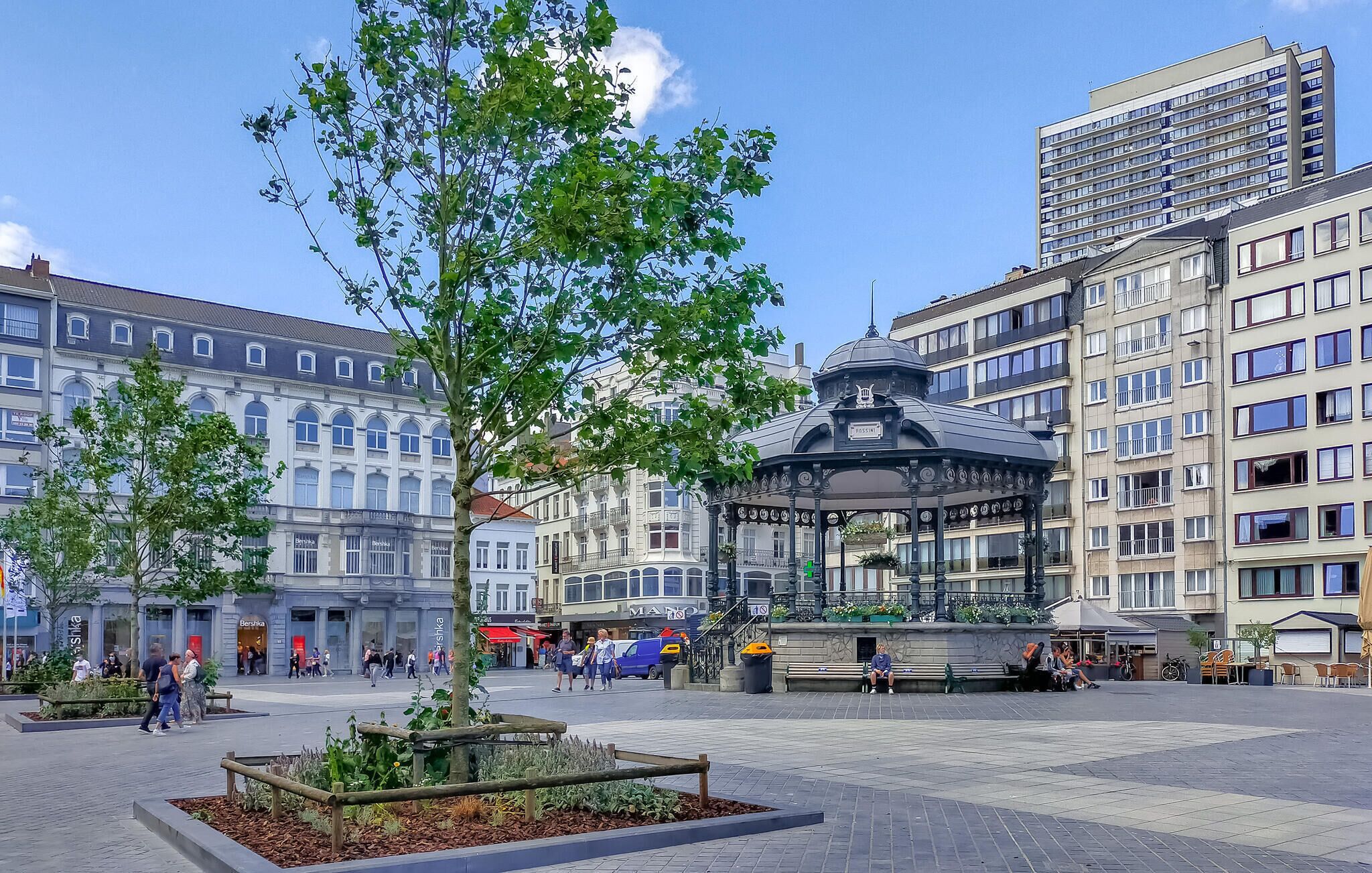 A public square with a gazebo, benches, and a tree.