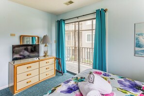 A bedroom with a bed, a dresser, a television, and a window with curtains. - Lake-View Balcony, Pool Access! Sunset Beach Condo (Sunset Beach)