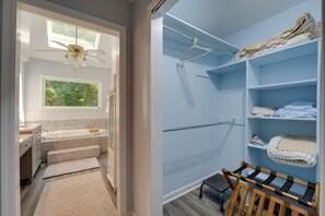 A bathroom with a bathtub, a shower area, and a vanity with a sink. - Group Getaway w/ Private Yard in Marietta (Marietta)