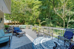 A deck with outdoor furniture, a patterned rug, and a white railing. - Group Getaway w/ Private Yard in Marietta (Marietta)
