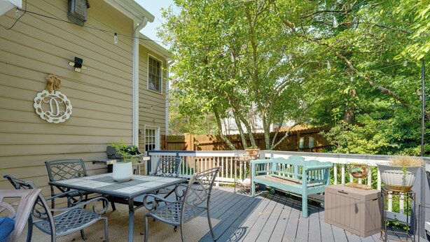 Eine Terrasse mit Gartenmöbeln, einem Grill und einem Blumentopf.