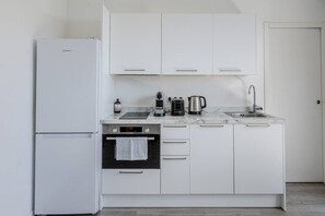 A modern kitchen with a white refrigerator, oven, and cabinets, a sink, and a coffee maker. - Maupassant Terrace | 2 min from the beach (Antibes)