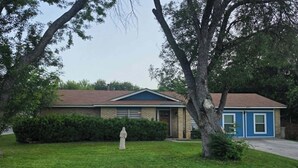 Ein Wohnhaus mit Rasen, einer Statue und einer blauen Garage.