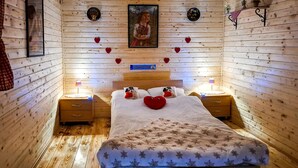 A cozy wooden room with a bed, nightstands, and decorative items. - Beautiful home in Ludbreg with sauna (Ludbreg)