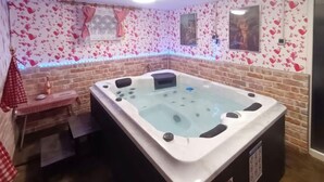 A hot tub in a room with brick walls and heart-patterned wallpaper. - Beautiful home in Ludbreg with sauna (Ludbreg)