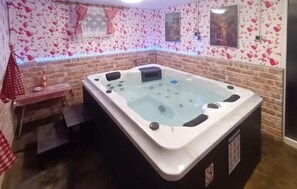 A hot tub in a room with brick walls and heart-patterned wallpaper. - Beautiful home in Ludbreg with sauna (Ludbreg)