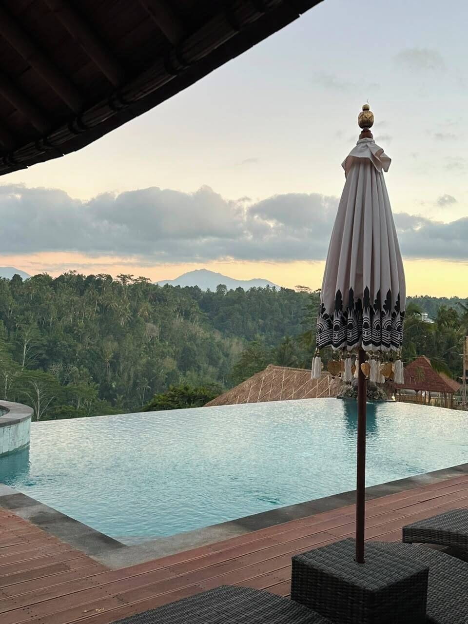 A poolside area with a view of a forested mountain range.