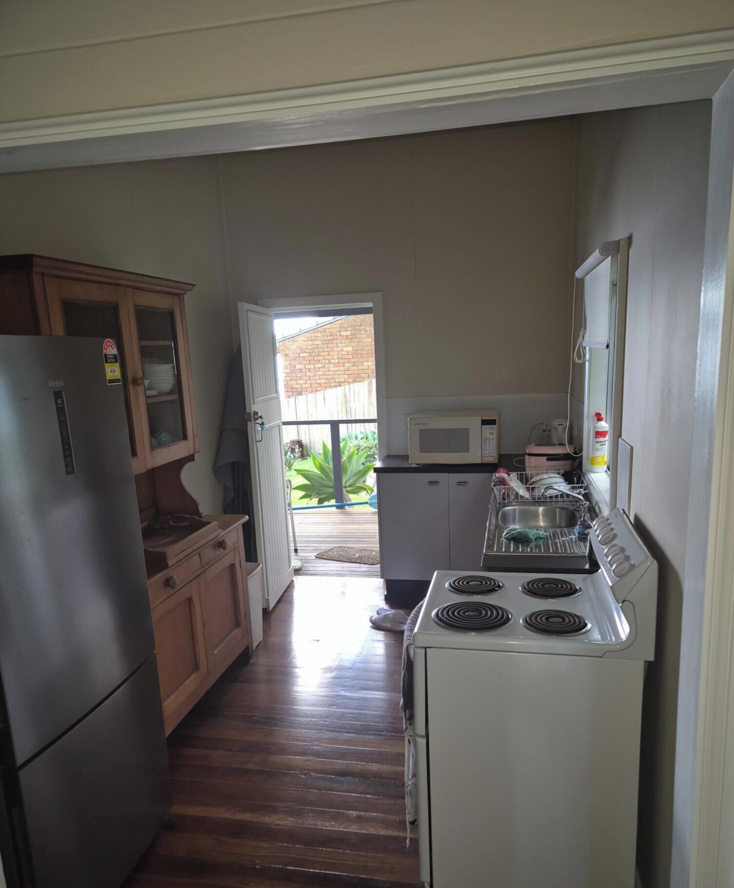A kitchen with a refrigerator, microwave, stove, and cabinets.