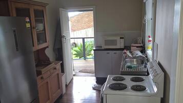 A kitchen with a refrigerator, microwave, stove, and cabinets.