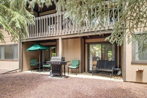 Eine Terrasse im Freien mit Grill, Sitzgelegenheiten und einem überdachten Bereich.
