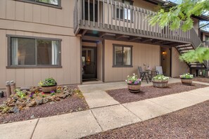 A two-story building with a covered patio area, outdoor seating, and potted plants. - Great for Families! Pinetop Sanctuary w/ Patio (Pinetop)