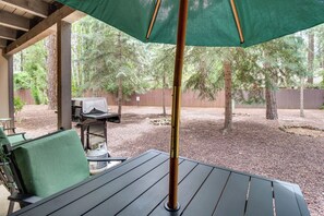 An outdoor patio with a table and chairs, a barbecue grill, and a covered area with a green umbrella. - Great for Families! Pinetop Sanctuary w/ Patio (Pinetop)