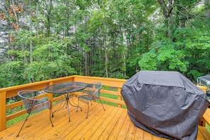 A wooden deck with a covered grill and metal tables and chairs. - Rustic Cabin w/ Phoenix Mtn Views & Trail Access! (Lansing)