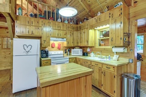 A cabin-style kitchen with wooden cabinets, a refrigerator, stove, microwave, and a sink. - Rustic Cabin w/ Phoenix Mtn Views & Trail Access! (Lansing)