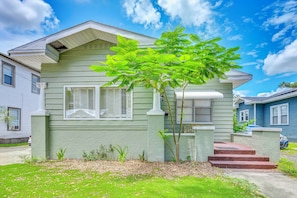 A two-story house with a green exterior, white trim, and a small tree in the front yard. - Extended Group Getaway 2 Mi to Dtwn & Ybor City! (Tampa)