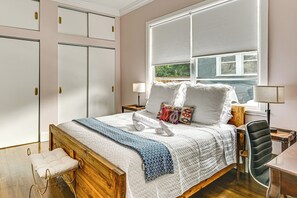 A bedroom with a large bed, a wooden bench, a desk, and a chair. - Extended Group Getaway 2 Mi to Dtwn & Ybor City! (Tampa)