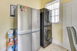A compact kitchen with a stainless steel refrigerator, a built-in oven, and a washing machine. - Extended Group Getaway 2 Mi to Dtwn & Ybor City! (Tampa)