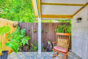A wooden bench with a cushion, a tiled floor, a wooden fence, and potted plants. - Extended Group Getaway 2 Mi to Dtwn & Ybor City! (Tampa)