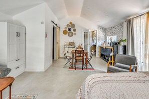 A modern living room with a dining area, a kitchen, and a bathroom visible through an open door. - Extended Group Getaway 2 Mi to Dtwn & Ybor City! (Tampa)