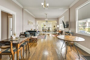 A spacious living room with a wooden dining table, comfortable seating, and a chandelier. - Extended Group Getaway 2 Mi to Dtwn & Ybor City! (Tampa)