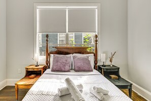 A neatly arranged bedroom with a wooden bed, two bedside tables, and a window with blinds. - Extended Group Getaway 2 Mi to Dtwn & Ybor City! (Tampa)