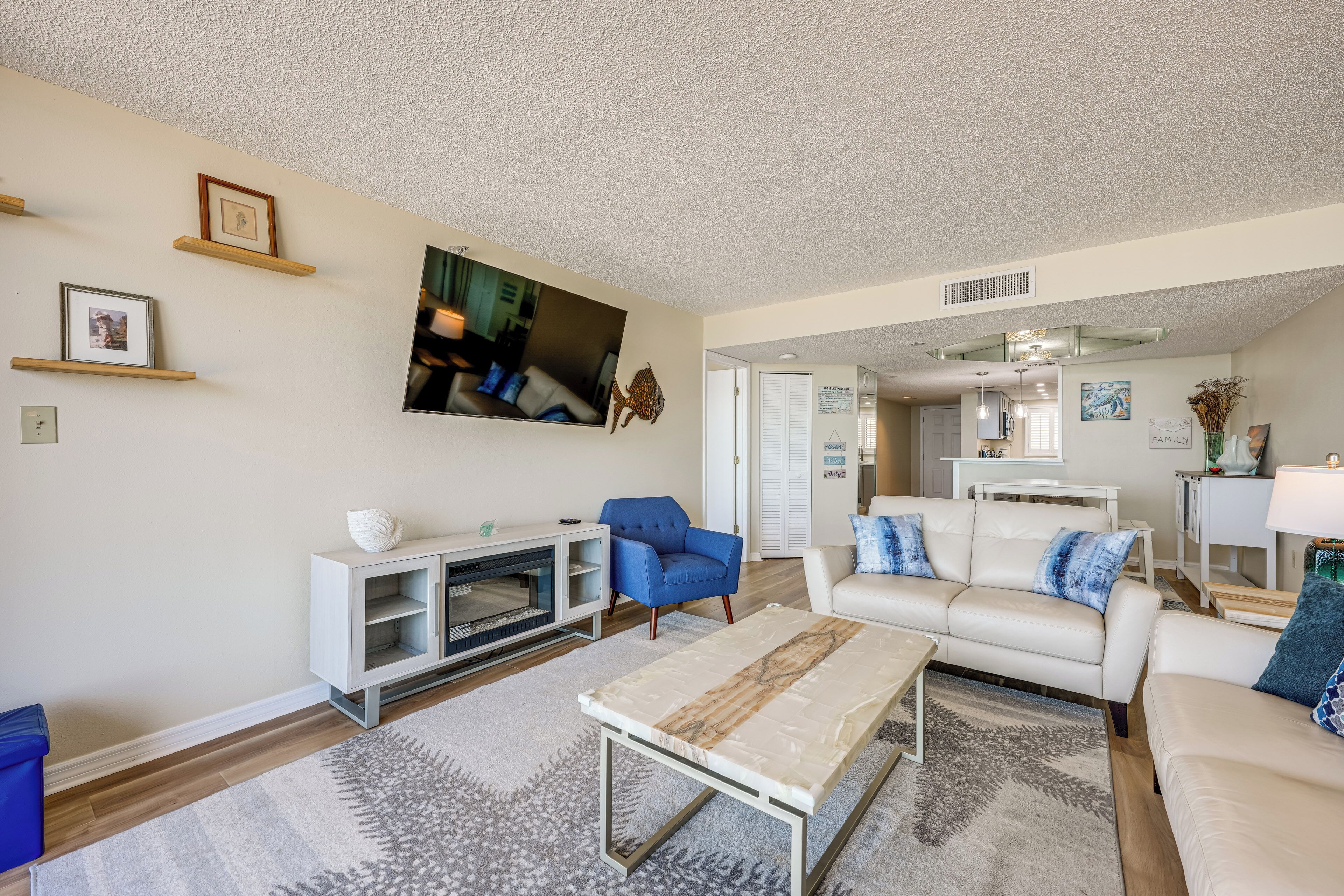 A living room with a sofa, a coffee table, a TV, and a fireplace.