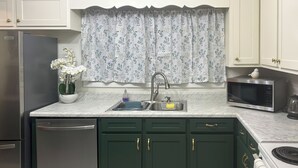 A kitchen with a dishwasher, sink, microwave, and stove. - Golf & Chill! Family-Friendly Augusta Home (Augusta)