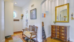 A hallway with a wooden chair, a dresser, and a mirror on the wall. - Charming Waterfront Home with Mt Rainier View (Olympia)