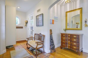 A hallway with a wooden chair, a dresser, and a mirror on the wall. - Charming Waterfront Home with Mt Rainier View (Olympia)