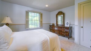 A bedroom with a bed, dresser, mirror, and window. - Charming Waterfront Home with Mt Rainier View (Olympia)