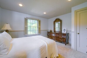 A bedroom with a bed, dresser, mirror, and window. - Charming Waterfront Home with Mt Rainier View (Olympia)