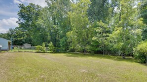 A grassy yard with trees and a building in the background. - Columbus Home Near Parks, Shops & Dining (Columbus)
