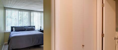 Una camera da letto con un letto, una finestra con persiane e una porta.