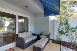 A covered patio area with wicker furniture and a white fence. - Private Patio, Yard! Townhome Near Pensacola Beach (Gulf Breeze)