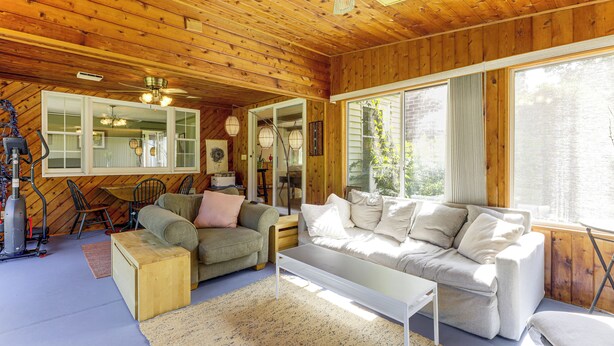 Ein gemütliches Blockhaus-Interieur mit Holzbalkendecke, einer Couch, einem Couchtisch und einem Laufband.