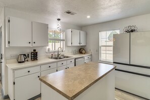 A modern kitchen with white cabinets, a central island, and a built-in refrigerator. - 2 Mi to Old Town ABQ! Remodeled Retreat w/ Yard (Albuquerque)