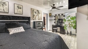 A modern bedroom with a large bed, a ceiling fan, and artwork on the walls. - Room for 6 Cars on Balloon Fiesta Weekend (Albuquerque)